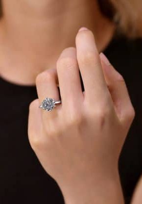 Hand model wearing a diamond engagement ring.